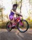 A girl riding a pink Frog 53 bike