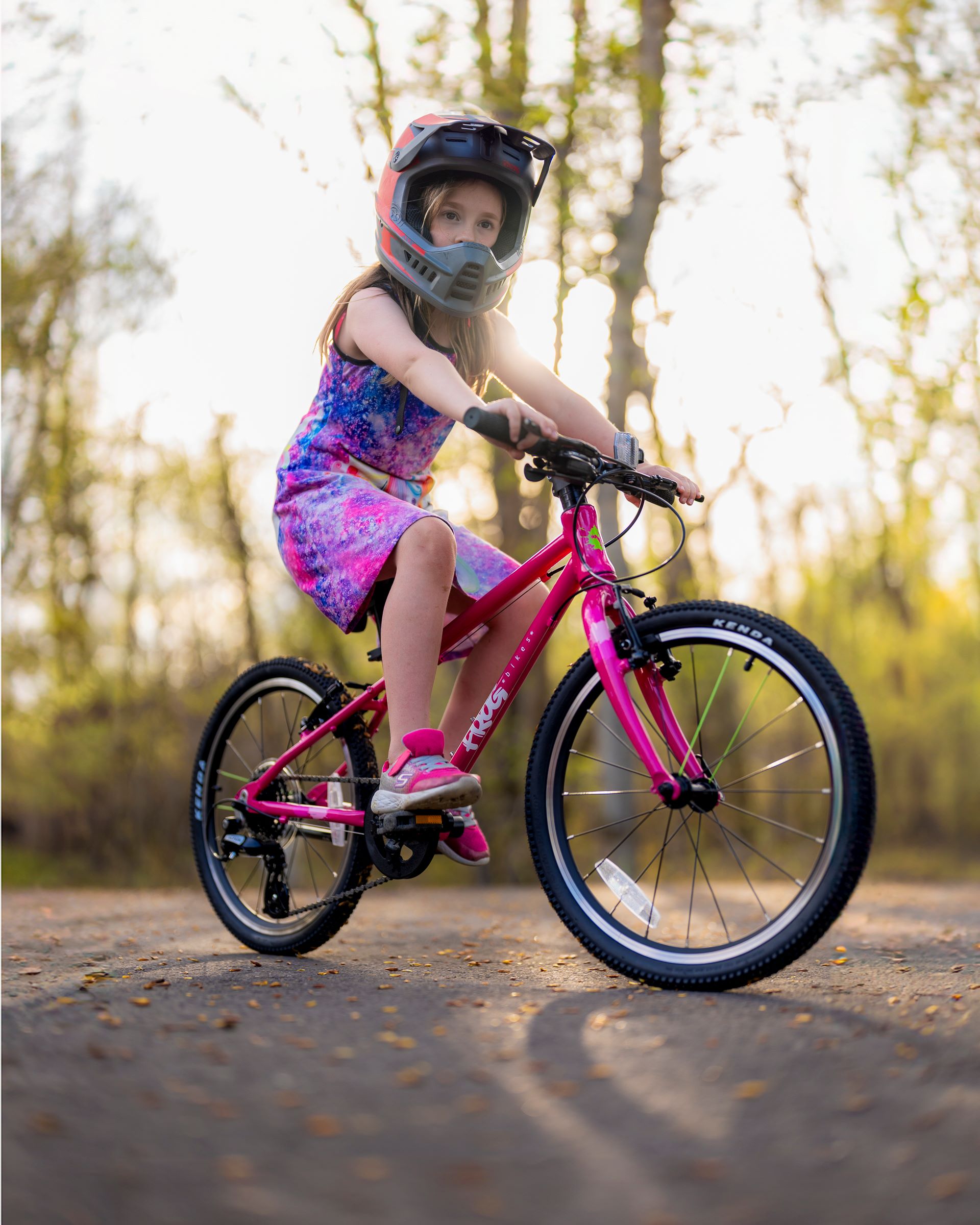 A girl riding a pink Frog 53 bike