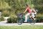 A woman with 2 children riding a Bicicapace Classicona cargo bike in a park