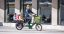 A woman with children riding a green Bicicapace Justlong cargo bike