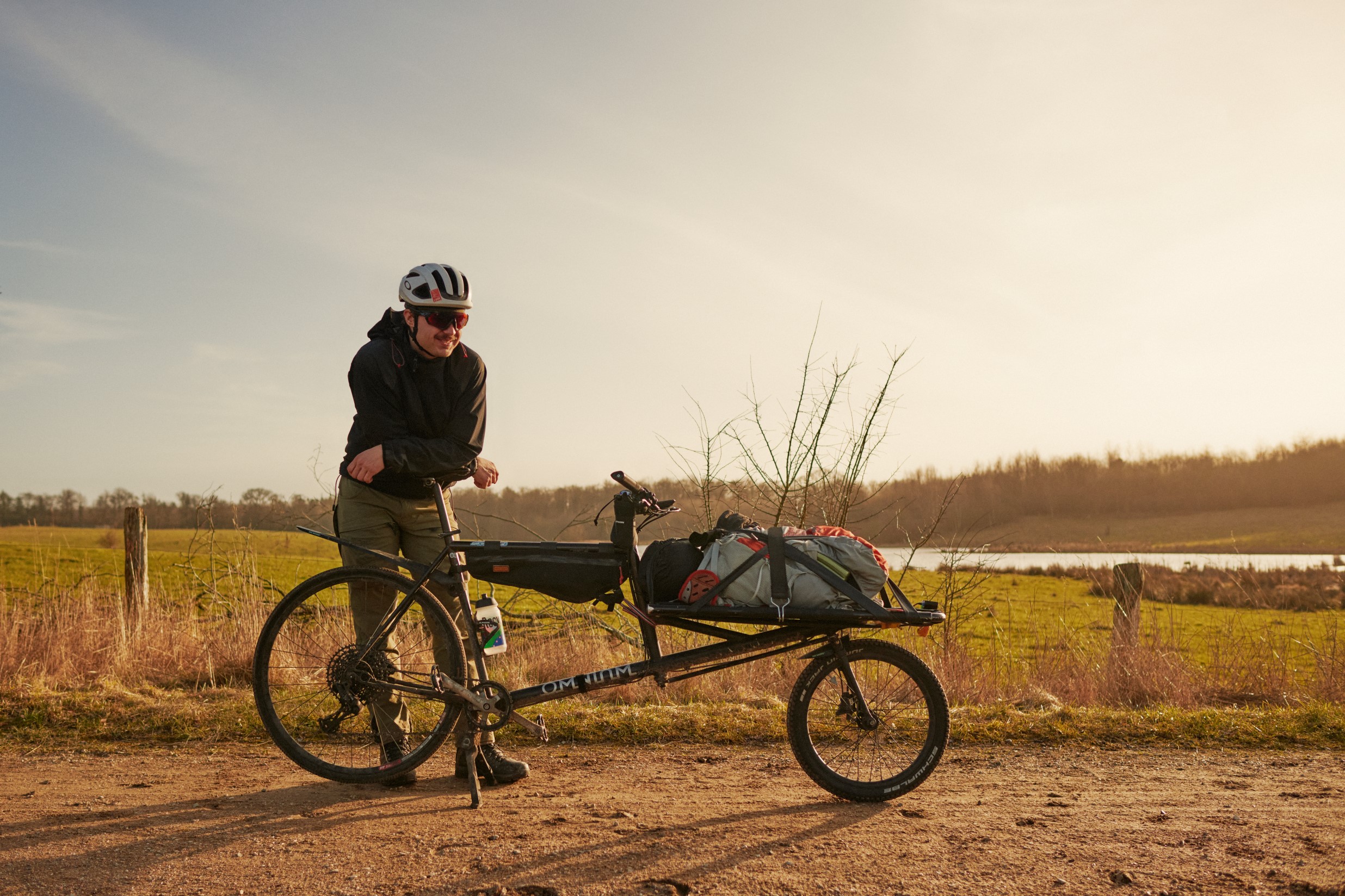 A man leaning on a Omnium Cargo v3 bike in the nature