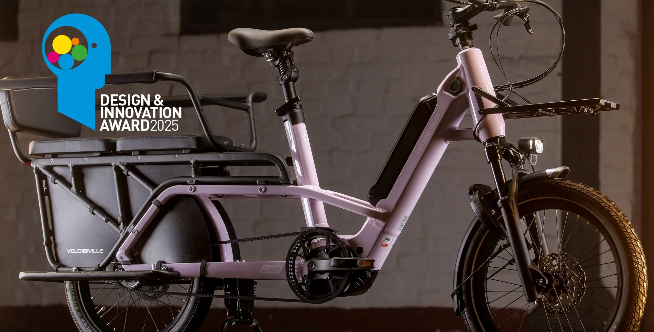 A pink Velo de Ville Loady bike in front of a wall