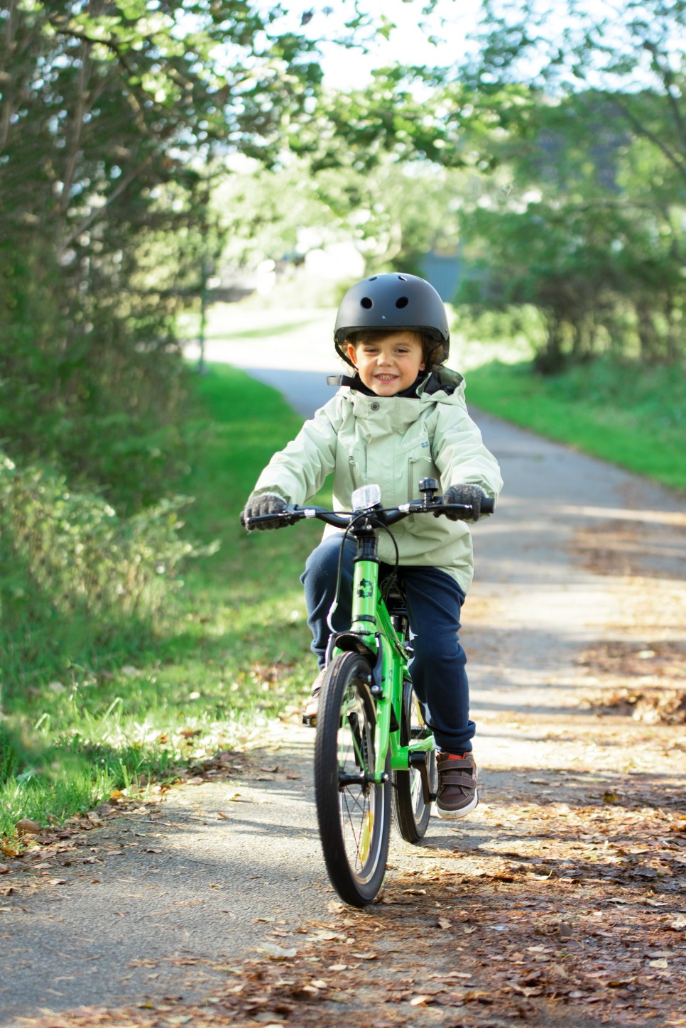 A boy riding a green Frog 47 bike