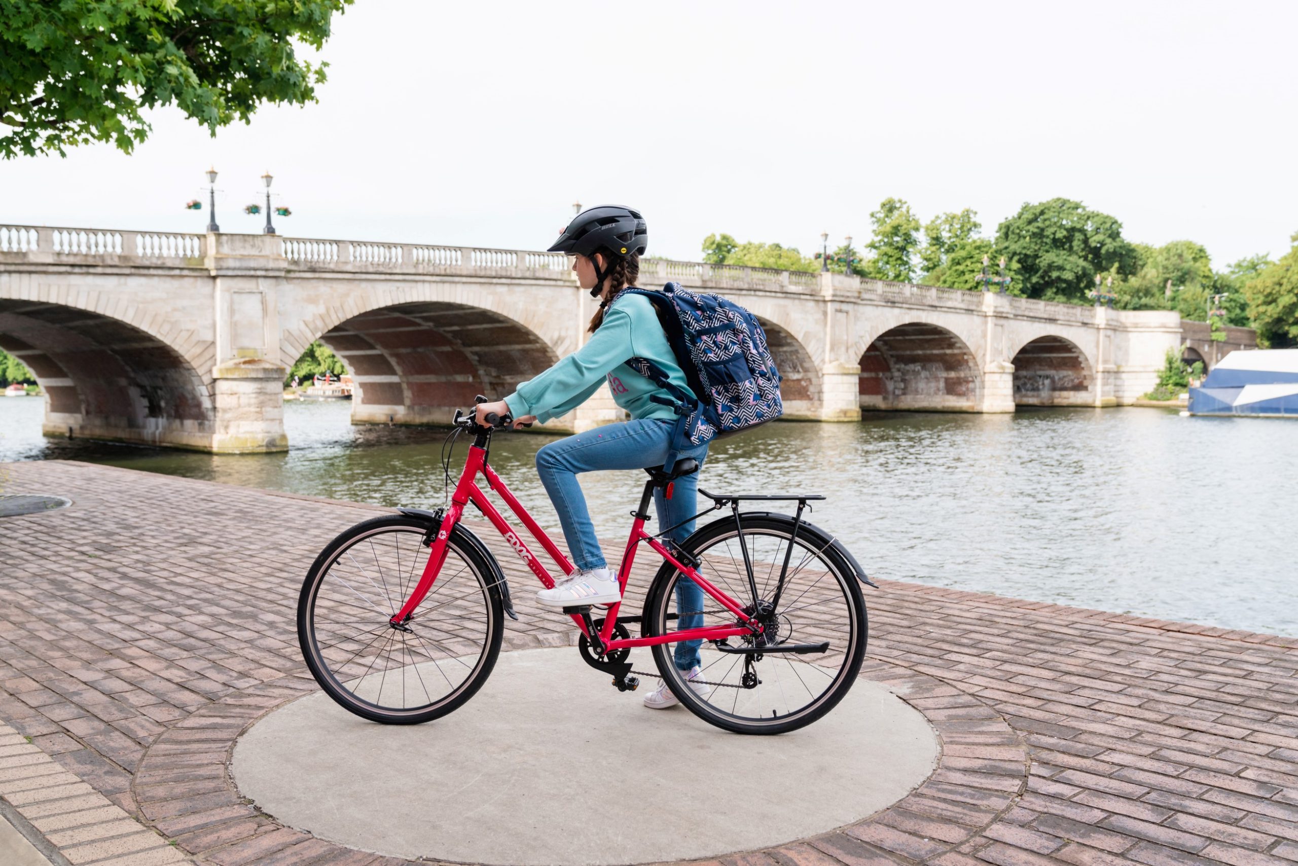 A girl sitting on a Pink Frog City 67 bike
