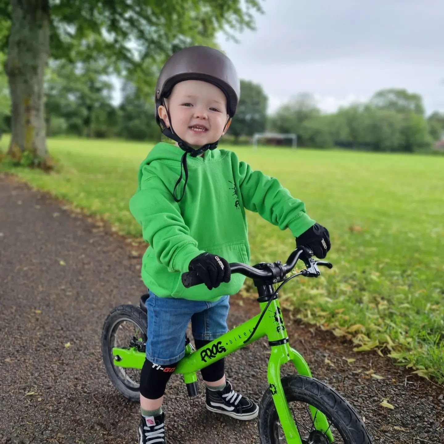 A child on a green Frog Tadpole bike