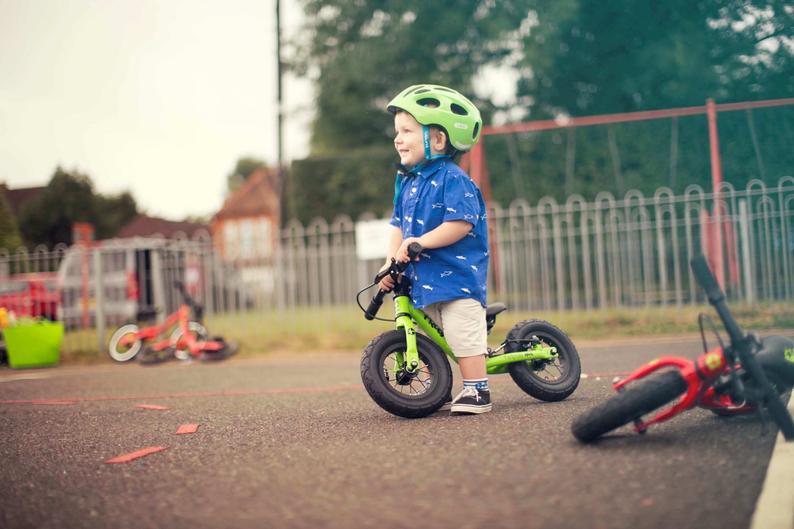 A child on a green Frog Tadpole Mini bike on a playground