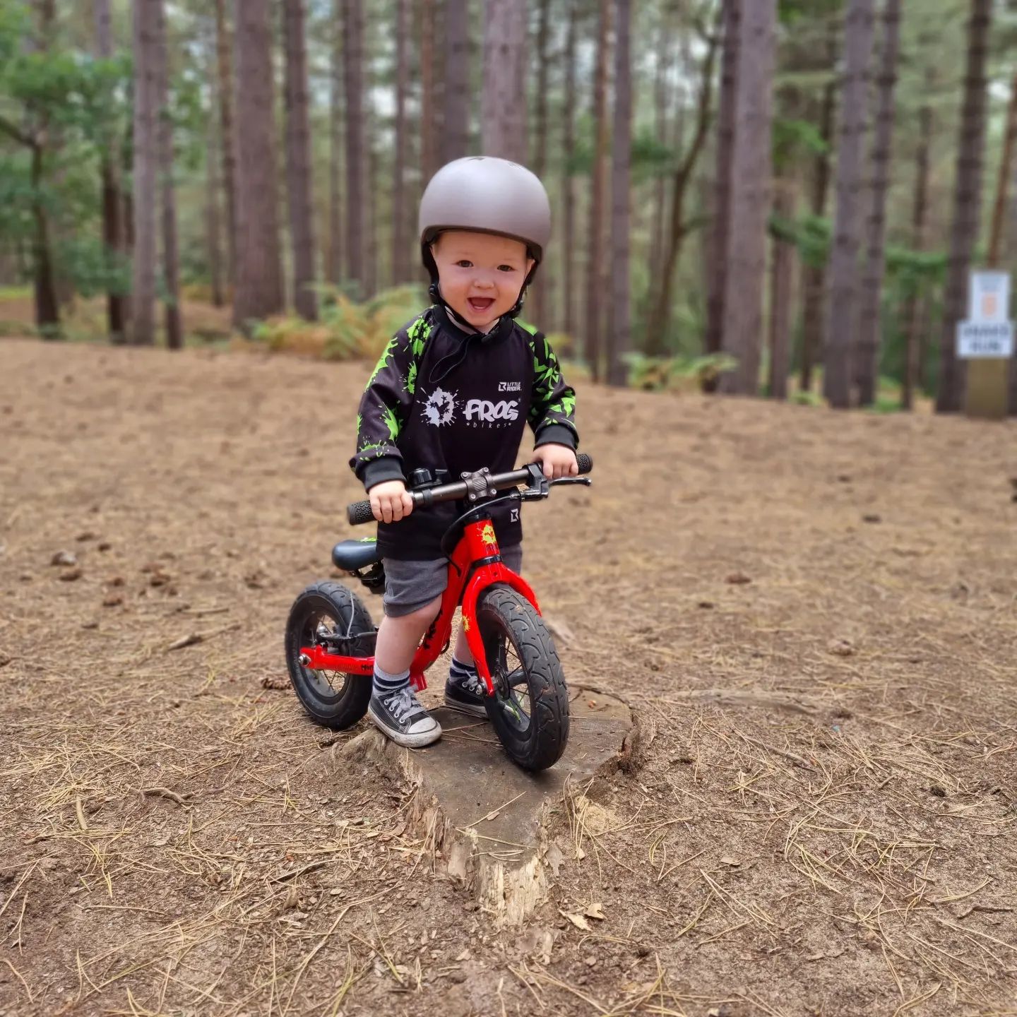 A child on a red Frog Tadpole Mini bike in a forest
