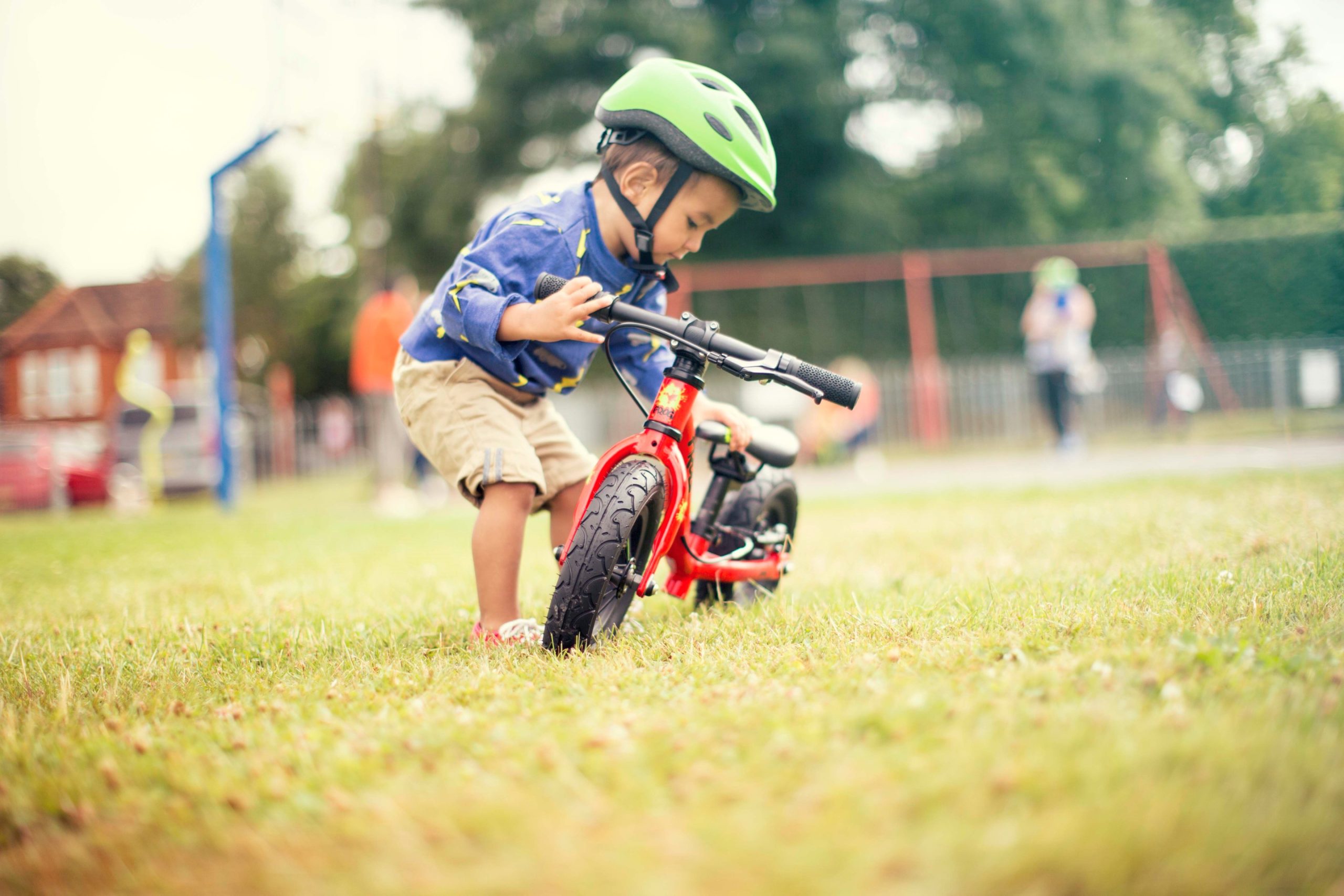 A child on a red Frog Tadpole Mini bike in the grass