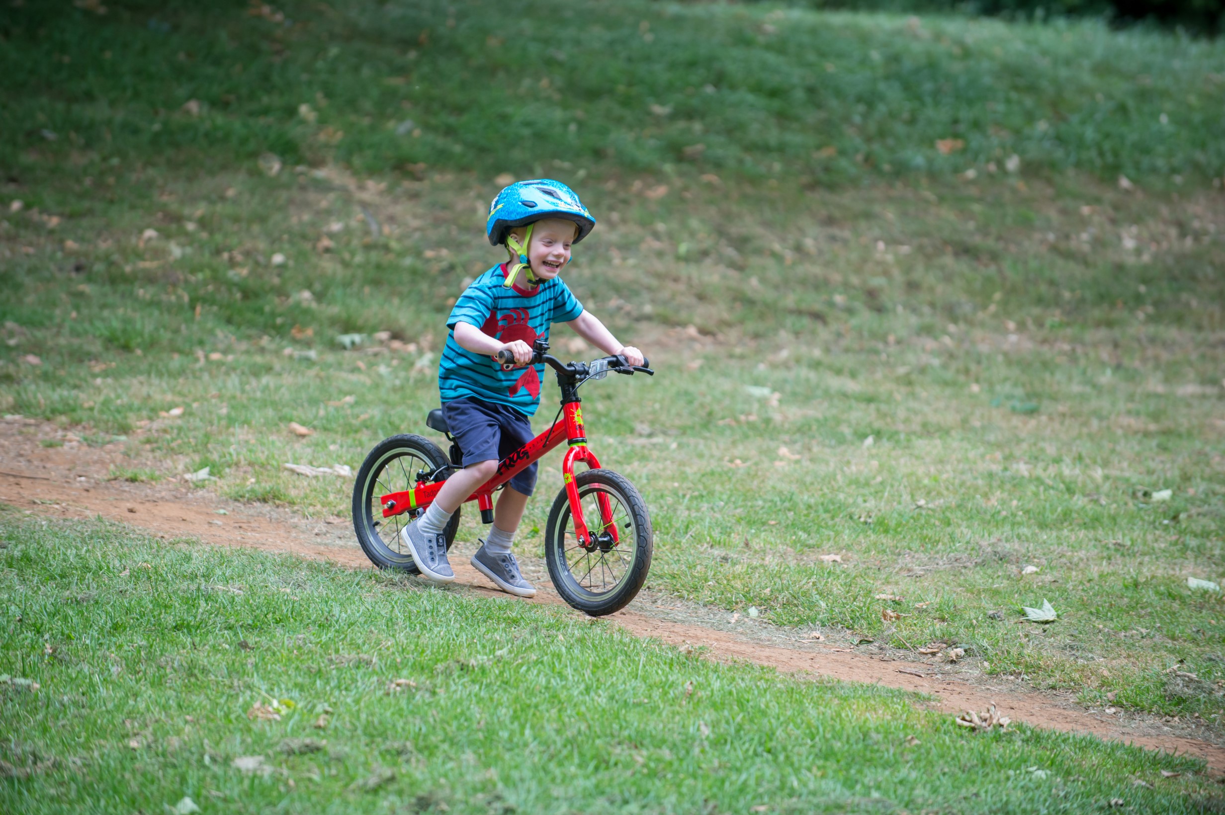 A child riding a red Frog Tadpole Plus bike