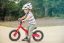 A child on a pumptrack with a red Frog Tadpole bike