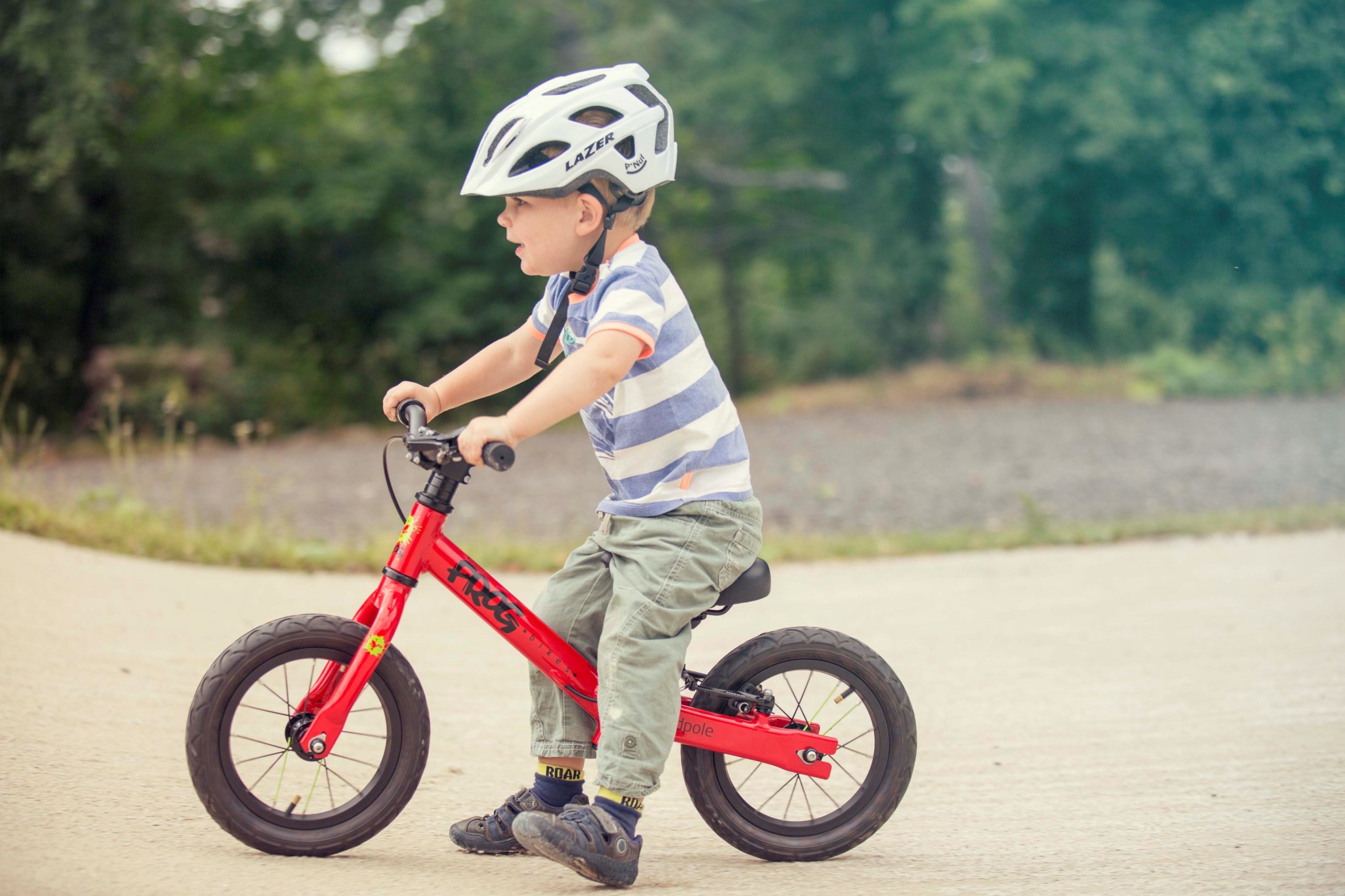 A child on a pumptrack with a red Frog Tadpole bike