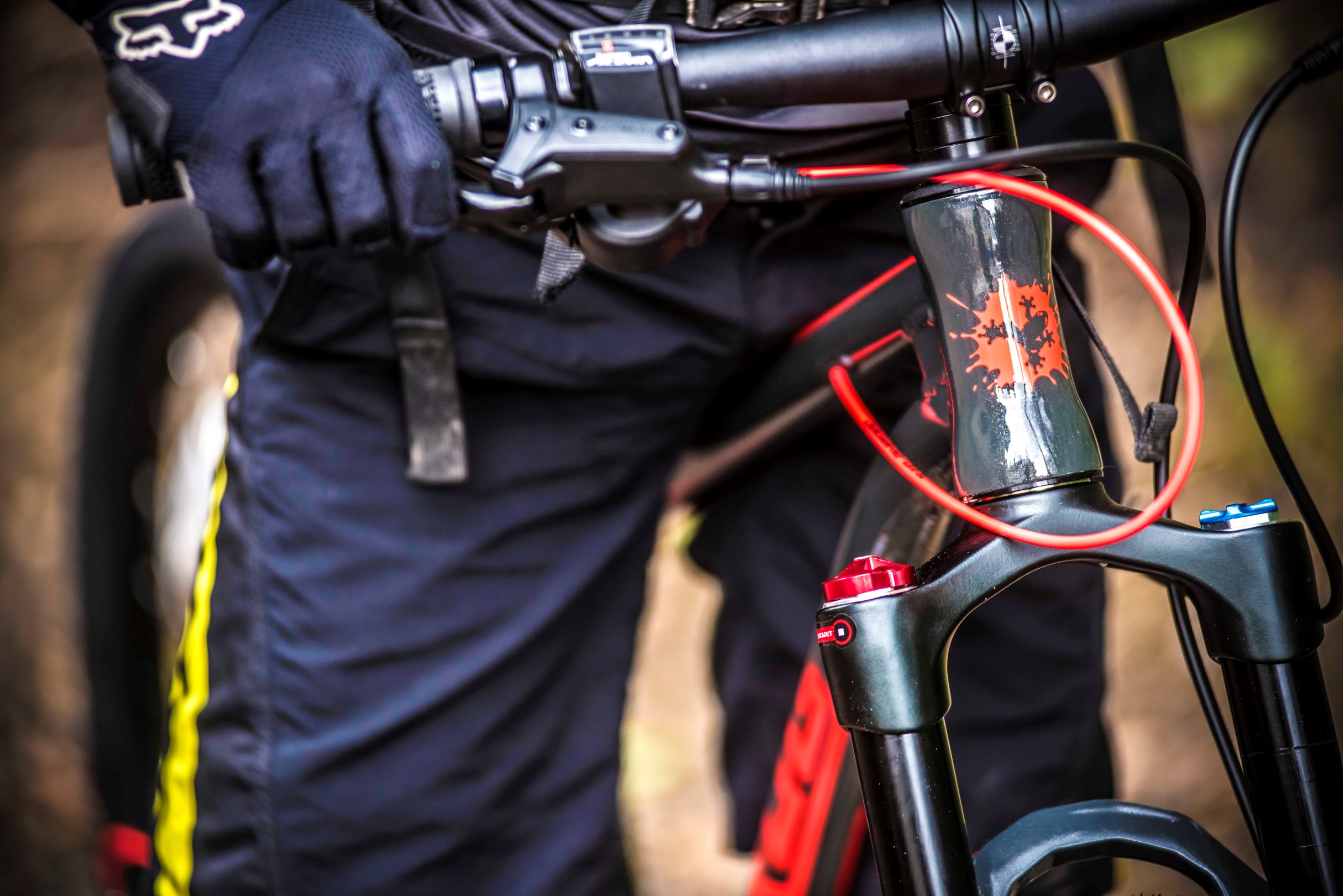 A close up of the handlebar of a Frog Mountain bike held by a kid 