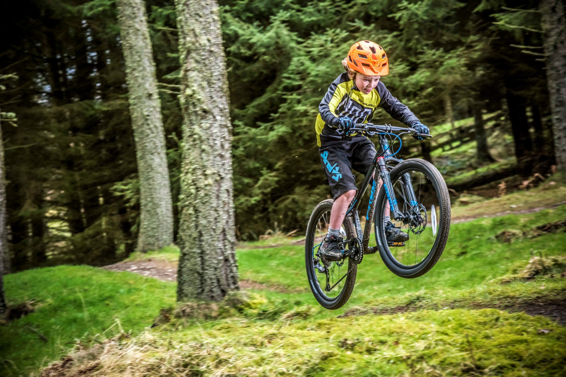 A kid jumping on a Frog Mountain 62 bike