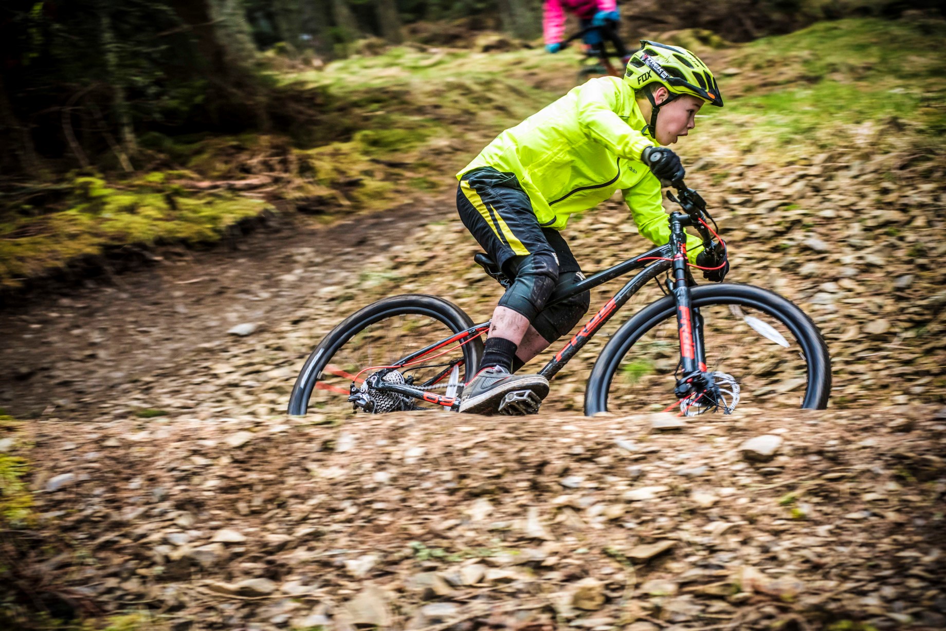 A boy riding a trail on a Frog Mountain 69 bike
