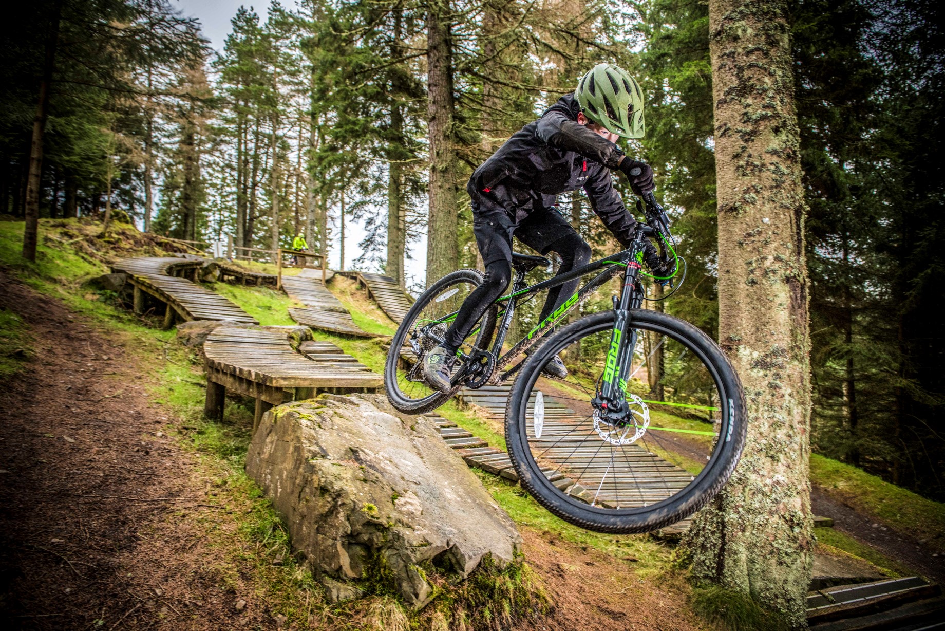 A boy dropping from a drop on a Frog Mountain 69 bike