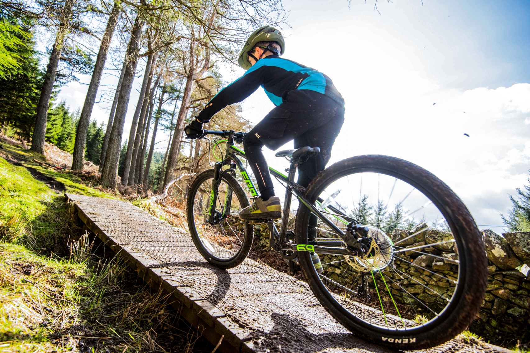 A boy riding up to a drop on a Frog Mountain 69 bike