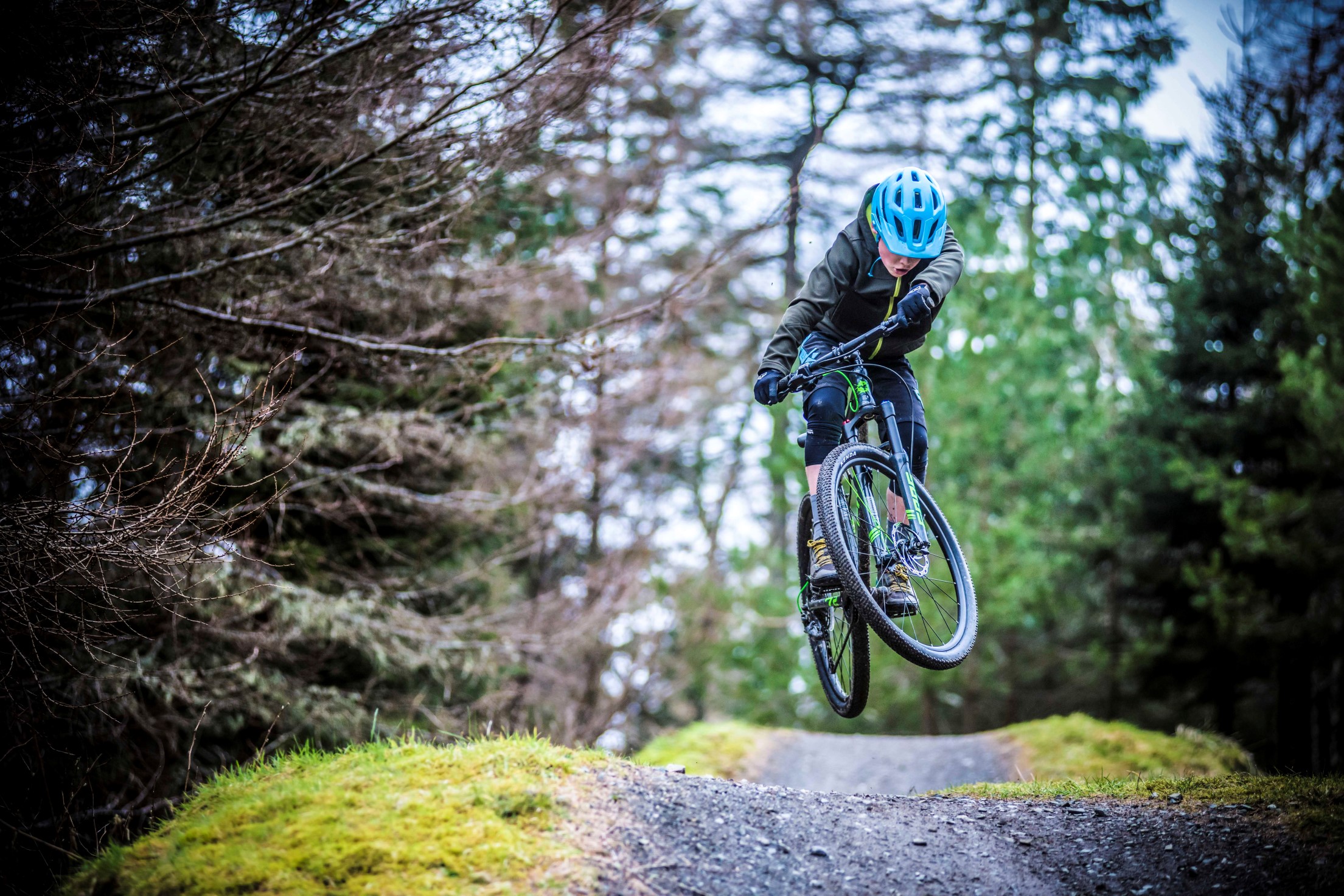 A kid jumping a tabletop on a Frog Mountain 72 bike