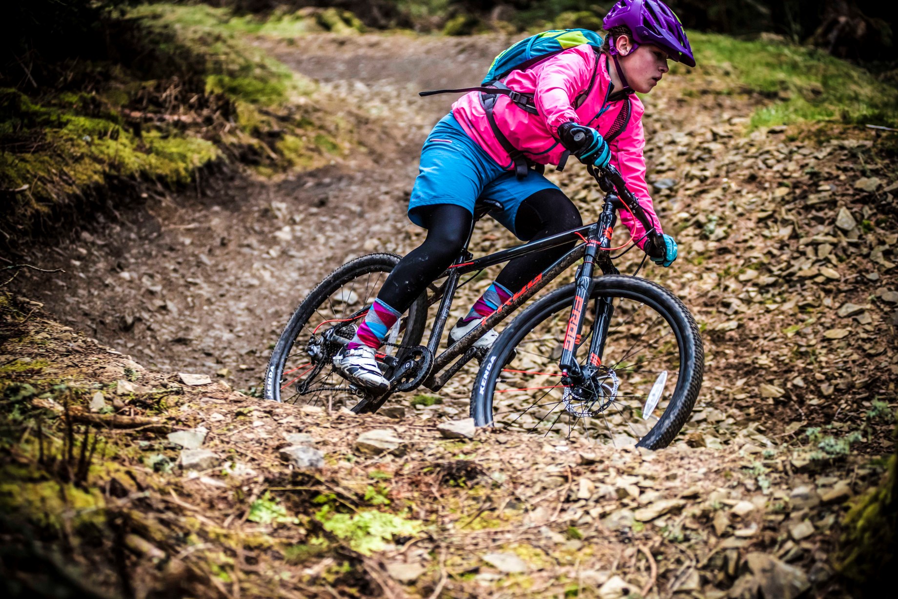 A girl riding a berm on a Frog Mountain 72 bike