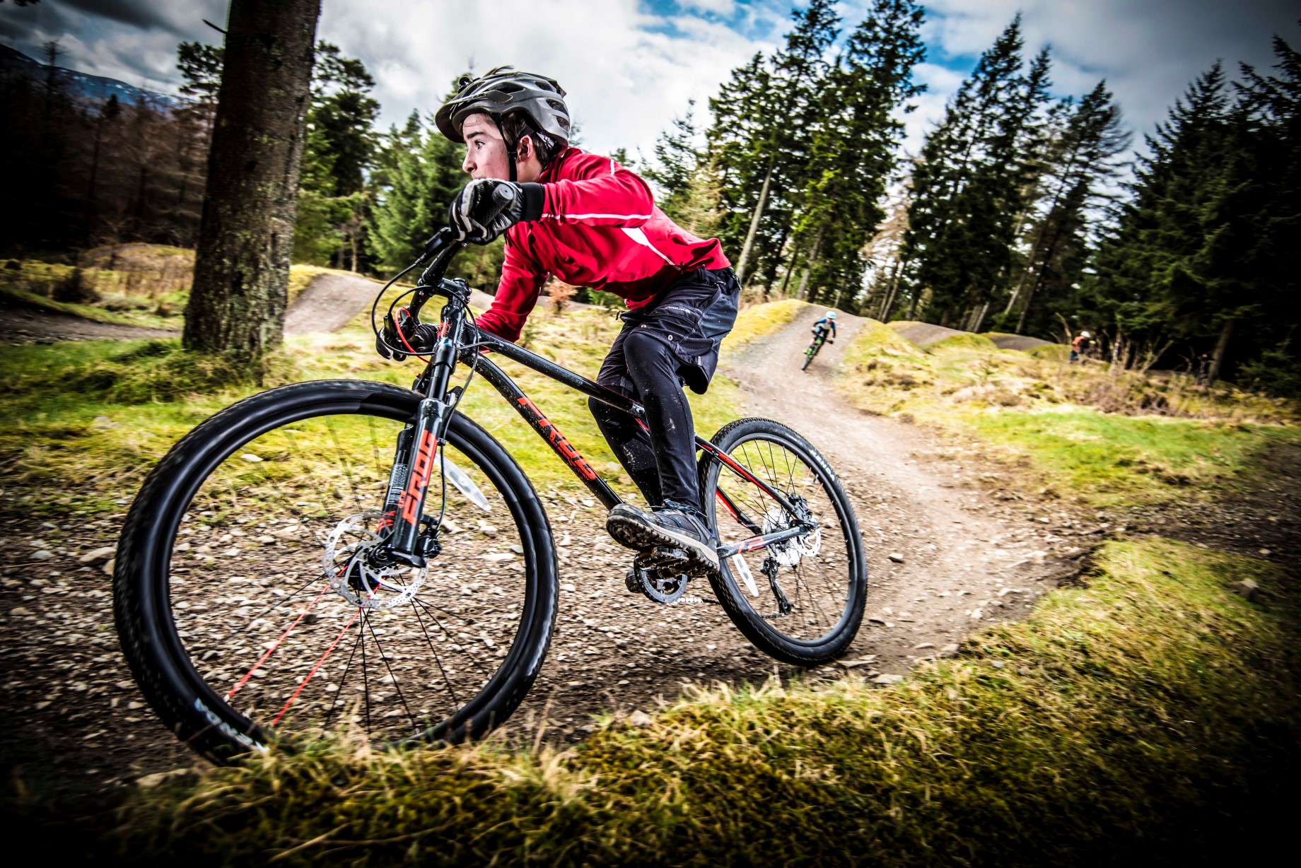 A boy riding a berm on a Frog Mountain 72 bike